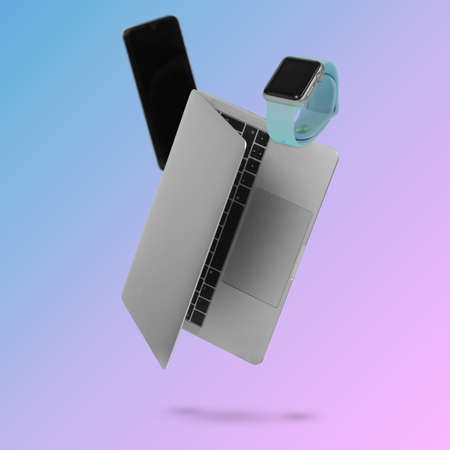 Laptop  computer, smart phone and smart watch while levitating in the air on a background illuminated by a blue and pink color gradient. Creative minimal background. Pop art, conceptual art. Suitable for advertising, marketing, adsの写真素材