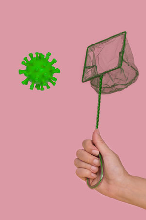 Human hand holding a net to catch the coronavirus in one hand.Creative minimal humorous concept of...