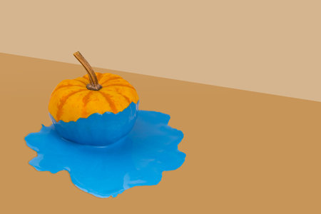 Creative autumn layout fresh pumpkin with dripping and melting paint on dark orange background. Minimal Holiday and season concept background. Copy space.の写真素材