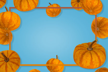 Pumpkins floating in the air with frame in a blue background, holiday decoration. Halloween or Thanksgiving concept background. Copy space.の写真素材