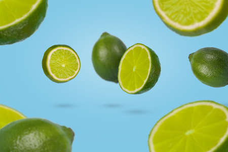 Minimal idea with fresh lime sliced floating in the air on pastel blue background. Minimal fruit concept. Vitamins, healthy diet concept. Creative concept with flying fruits.の写真素材