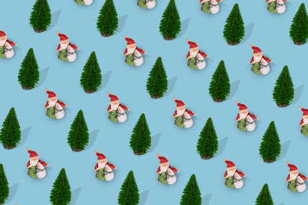 Creative pattern with Christmas tree and Santa Claus and Snowman in an embrace on a bright blue...
