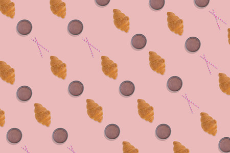 Creative pattern made of freshly baked croissant, glass of  chocolate milk and straw on bright pink background. Minimal homemade pastry concept.の写真素材