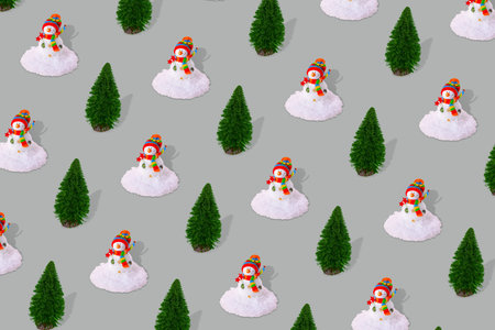 Creative winter nature pattern made of snowman with snow and pine tree on gray background.