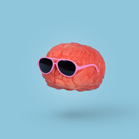 Funny minimal idea with a human brain wearing sunglasses floating in the air isolated on a blue...