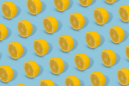 Trendy Summer pattern made with yellow lemon slice on bright blue background. Minimal summer...