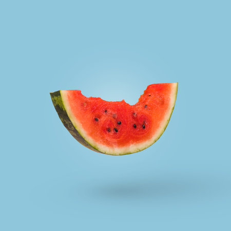 Watermelon slice isolated on a bright blue background. Summer minimalist concept.