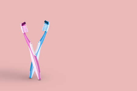 Creative idea made of two toothbrushes pink and blue bristles in an embrace, isolated on bright pink background. Copy space.の写真素材