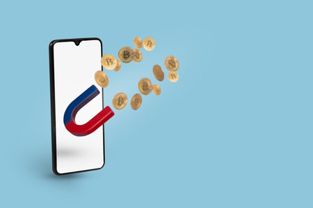 Mobile phone with Magnet attract bitcoin Golden coins. Success Attracting investments concept. Creative cryptocurrency or blockchain concept. Stock Market, digital gold money and stock businessの写真素材