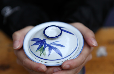 A Hand Holding a Chinese Tea Cupの写真素材