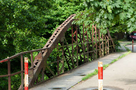 an old, rusty bridge over a river, closed for carsの写真素材
