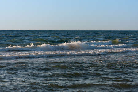 late evening at the Baltic Sea, the sun reflects on the wavesの写真素材