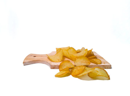 delicious potato chips on a cutting board isolated on white background. Potato chips are unhealthy because they are high in calories and low in nutrients. and can make obesity becaの写真素材