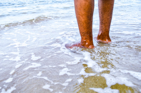 Low angle view, Asian man's feet in the sea. With soft sea water and sea sand. Focus on feet , Noisy, exposure, similar othersの写真素材