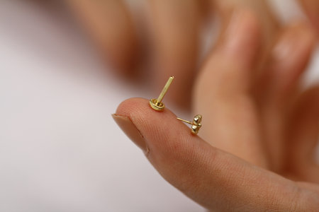 Female hand with golden jewelry on a white background, close up.tragus jewelryの写真素材