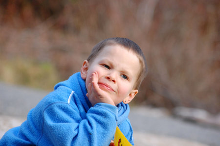 Photo of a little boy thinking about something very important.  It's a rare quiet moment, deep in thought.の写真素材