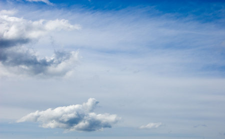 Photo of blue sky with both wispy white overcast and fluffly white clouds situation mostly to the...