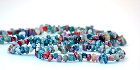 Multi colored rock / stone necklace is draped in pleasing curves against a white background.の写真素材