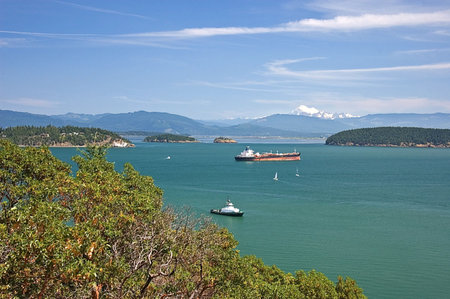 This stunning ocean view shows a barge and many boats on the aquamarine colored water with Mount Baker in the distance in Washington State America.の写真素材