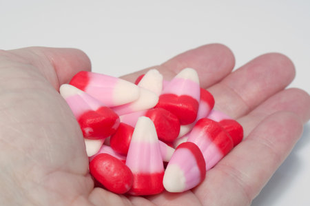 This hand is full palm up, with Valentine colored red, pink and white candy corn.の写真素材