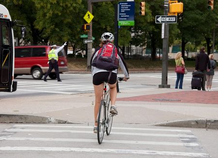 BALTIMORE, MD - SEPTEMBER 9, 2009: - An unidentified woman riding a bike is commuting to save gas for in her commute.  Photo taken on September 9, 2009 in Baltimore, MD.のeditorial素材