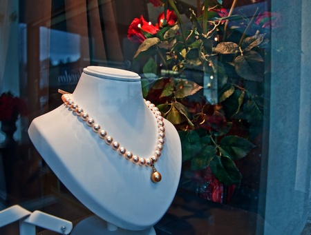 This is a pearl drop necklace store display with red roses with dramatic lighting for a romantic gift idea, especially for Valentineの写真素材