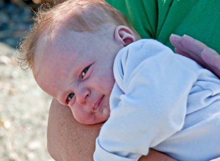 This adorable 2 month old baby girl infant is lying on her motherの写真素材