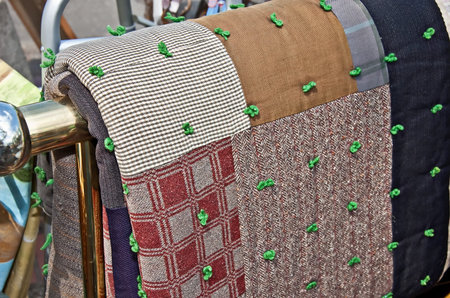 This is an antique quilt hanging on a brass quilt rack    It