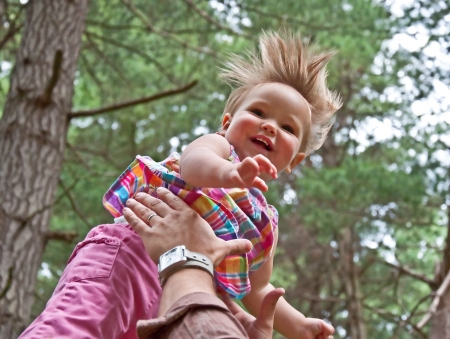 toddler girl 1 year old, Caucasian is happy while her dad is throwing her in the airの写真素材