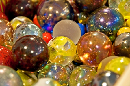 This is a closeup of many multi colored glass marbles   Very pretty and colorful childhood objects の写真素材