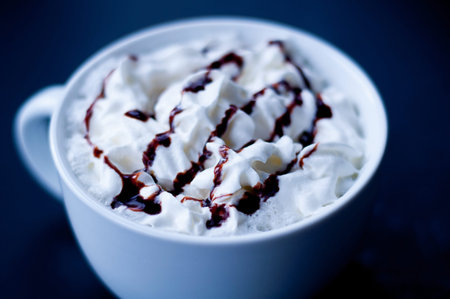 Cup of hot cocoa or mocha coffee closeup in a large white cup blurred.  Detailed fresh whipped cream...