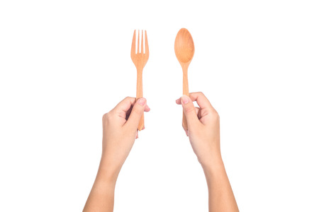Hand holding wooden spoon and fork isolated on white backgroundの写真素材