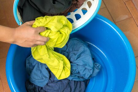 Women separate cloth from basket into the basin , hand wash.の写真素材