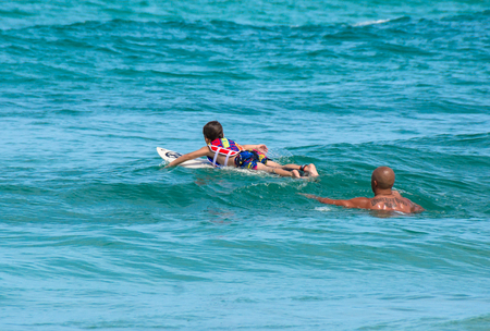PHUKET, THAILAND - SEPTEMBER 21: Father teaching his little son how to sufing in Kata beach - Phuket island, Thailand on September 21,2014.のeditorial素材