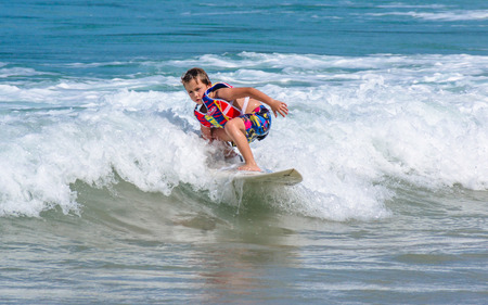 PHUKET, THAILAND - SEPTEMBER 21: A little Western boy practicing sufing in Kata beach -Phuket island, Thailand on September 21,2014. Kata beach is the paradise for surfer on Monsoon season.のeditorial素材