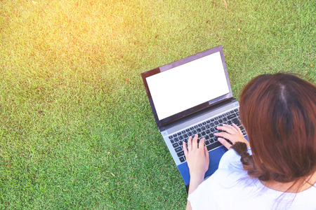 Woman using Laptop in park vintage styleの写真素材