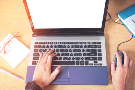 Top view Hand using laptop with blank screen on desk in home