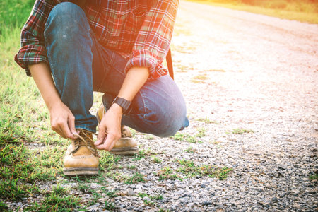 Traveler man hand's tying shoe laces on street traveler and holiday concept vintage toneの写真素材
