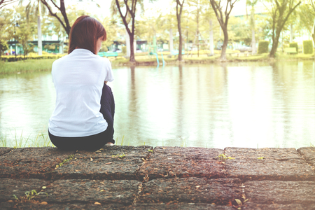 Lonely woman sitting on a wooden are Lonelyの写真素材