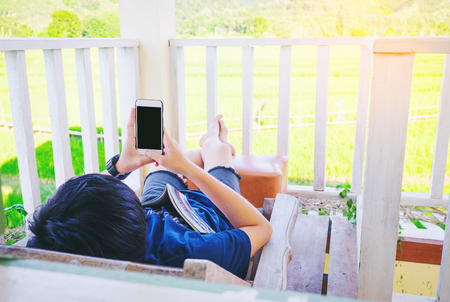 Young man relax on bed and enjoying on day timeの写真素材