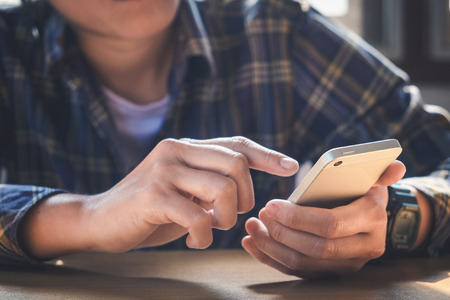 young man working from home using smart phoneの写真素材