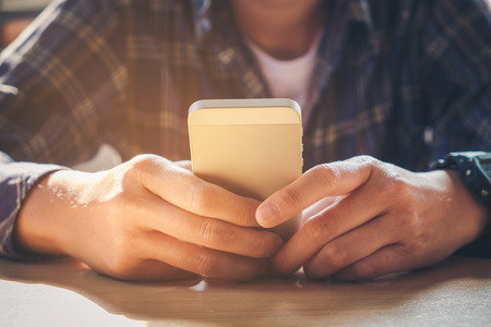 young man working from home using smart phoneの写真素材