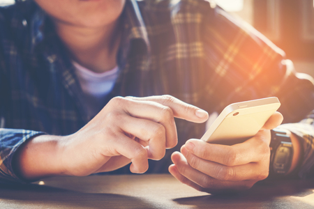 young man working from home using smart phoneの写真素材