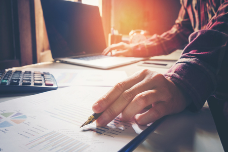 business man pointing his ideas and writing business plan at workplace,man holding pens and papers, making notes in documents, on the tableの写真素材