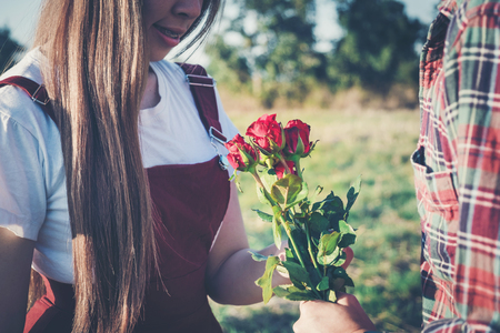 loving couple - man with rose waiting his woman in parkの写真素材