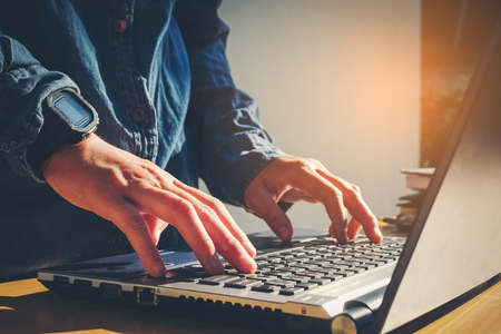 Man's using laptop with blank screen on desk in home interior. Business conceptの写真素材
