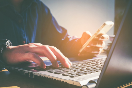 Man's using laptop with blank screen on desk in home interior. Business conceptの写真素材