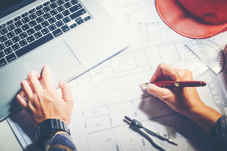 Architect or engineer working in office on blueprint. Architects workplace , blueprints, ruler, helmet and divider. Construction concept. Engineering toolsの写真素材