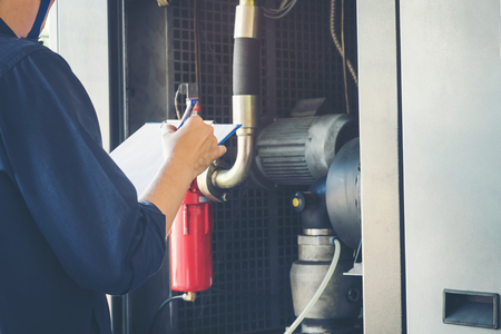 Technician is recording data Voltage or current in control panel of power plantsの写真素材