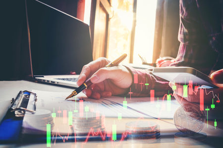 business man pointing his ideas Data and writing business plan at workplace,man holding pens and making notes trading graph of stock marketの写真素材
